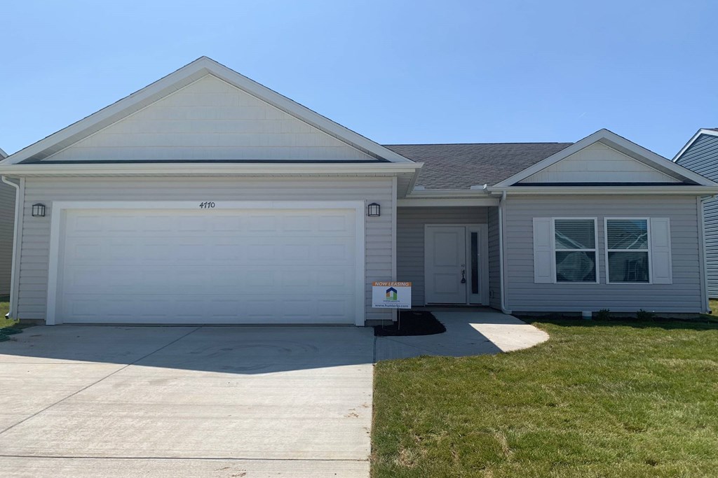 a house with a white garage door and a green lawn